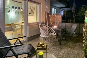 a patio with chairs and a table and a dining room at Am Silberbergblick in Bodenmais