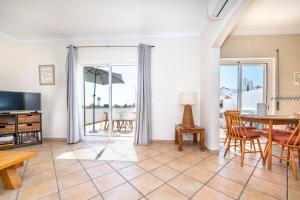 a living room with a table and a dining room at Quinta da Gomeira by Algartur in Cabanas de Tavira