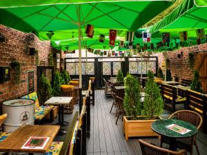 ein Restaurant mit Tischen und Stühlen und grünen Sonnenschirmen in der Unterkunft Vendome Hotel in Eskisehir