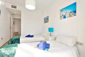 two beds in a room with white walls at CasaBella Marina Duquesa in Manilva