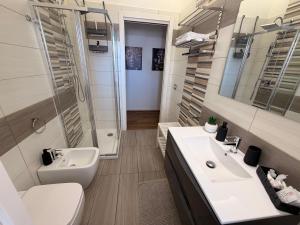 a bathroom with a sink and a toilet and a mirror at Lo Snodo Apartments cucina e parcheggio in Pomigliano dʼArco +8 photos