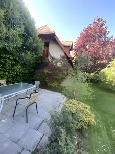 a ping pong table and chairs in a garden at Sous Les Bruyères in Sainte-Marguerite