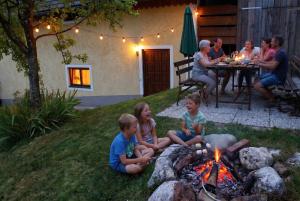 a group of children sitting around a camp fire at Ferienhaus Huber in Bleiburg