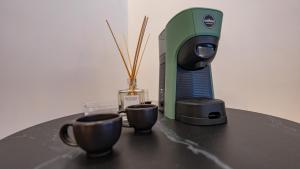 a coffee maker and two cups on a table at GG Spagna Luxury Suites in Rome