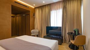 a hotel room with a bed and a television at GG Spagna Luxury Suites in Rome