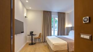 a hotel room with a bed and a window at GG Spagna Luxury Suites in Rome