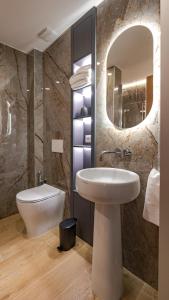 a bathroom with a sink and a toilet and a mirror at GG Spagna Luxury Suites in Rome +45 photos