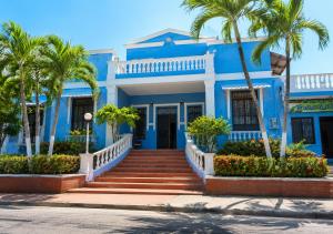 a blue house with palm trees in front of it at Renta Mar in Barranquilla