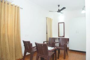 a dining room with a table and chairs and a mirror at Hotel Srinivas in Cochin