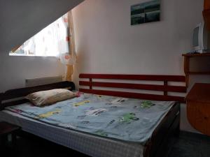 a bedroom with a bed with a blue blanket at Hangya panzió in Târgu Secuiesc