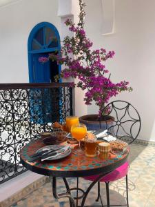 a table with glasses of orange juice on a balcony at Riad Safi - maison historique in Safi