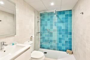a bathroom with a toilet and a blue tiled shower at CasaBella Marina Duquesa in Manilva