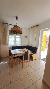 a living room with a table and chairs and a couch at Mecseki Farkasvár in Magyarhertelend