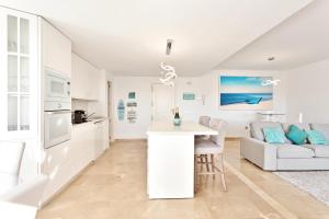 a kitchen and living room with a table and a couch at CasaBella Marina Duquesa in Manilva