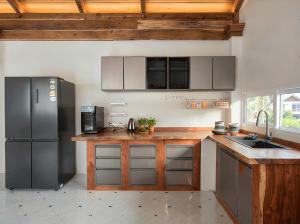 a kitchen with stainless steel appliances and wooden cabinets at Villa Monroe - Elegant Private Pool Villa in Ban Nok +6 photos