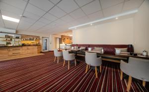 ein Esszimmer mit einem Tisch und weißen Stühlen in der Unterkunft Hotel Süderelbe in Hamburg