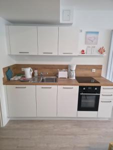 a kitchen with white cabinets and a sink at RheinStay Bingen in Bingen am Rhein