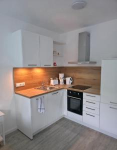 a kitchen with white cabinets and a sink at RheinStay Bingen in Bingen am Rhein +8 photos