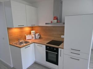 a kitchen with white cabinets and a sink at RheinStay Bingen in Bingen am Rhein