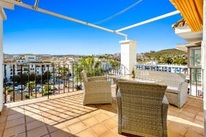 a patio with chairs and tables on a balcony at CasaBella Marina Duquesa in Manilva