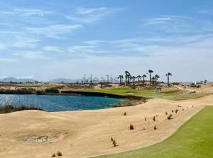 a group of people on a golf course next to a body of water at Bajo con barbacoa Solymar LAS TERRAZAS GOLF RESORT in Torre-Pacheco