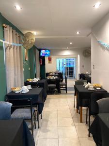 a dining room with black tables and chairs at plaza hotel in Termas de Río Hondo