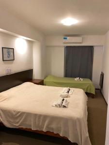 a hotel room with two beds with towels on them at plaza hotel in Termas de Río Hondo +24 photos