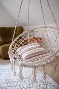 a white rope swing with a pillow on a rug at Pension Marie in Český Krumlov