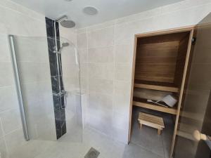 a bathroom with a shower and a bench in it at Pärnu Saunamaja saun, aed, mere lähedal ja tasuta parkimine in Pärnu