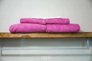 a pile of purple towels sitting on a wooden shelf at Wine Passion Room in Quartu SantʼElena +22 photos