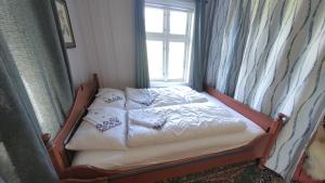 a bed in a room with a window at Suigard Veslestugo in Sauland