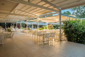 a patio with tables and chairs under a pergola at Hotel Favorit in Venus