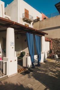 a building with blue curtains on the side of it at Labottega home in Lipari