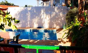 a swimming pool in front of a white fence at Borus Hostel in Puerto Iguazú
