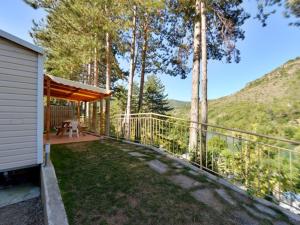 a balcony of a house with a view of a mountain at Camping Cascade Aveyron in Saint-Rome-de-Tarn