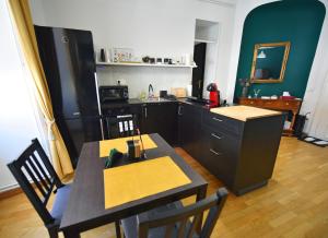 a kitchen with a table and chairs and a kitchen with a counter at Studio MAYA in Maribor