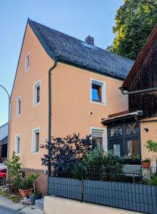 ein Haus mit einem Zaun davor in der Unterkunft Lindenhardt in Creußen