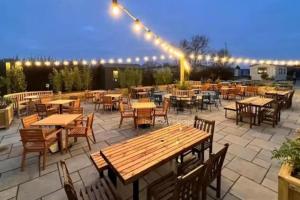 an outdoor patio with tables and chairs and lights at Glendale Holiday Park in Wigton