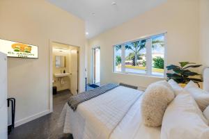 a bedroom with a bed and a window and a sink at El Jardin Inn in Miami
