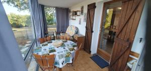 a dining room with a table and chairs and a window at Rosabelle in Beaulieu-sur-Dordogne