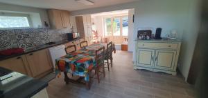a kitchen with a table and chairs in a kitchen at Rosabelle in Beaulieu-sur-Dordogne +4 photos
