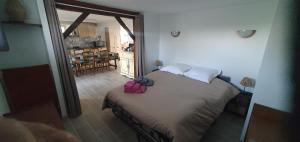 a bedroom with a bed with a pink bag on it at Rosabelle in Beaulieu-sur-Dordogne