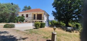 a white house with a table and chairs in the yard at Rosabelle in Beaulieu-sur-Dordogne