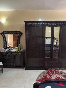 a living room with a cabinet and a mirror at Super appartement in Thiès