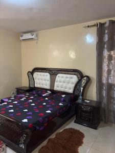 a bedroom with a bed with a black and white comforter at Super appartement in Thiès