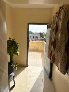 an open door to a balcony with a plant at Super appartement in Thiès