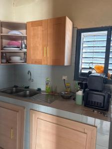 a kitchen with a sink and a microwave at Super appartement in Thiès
