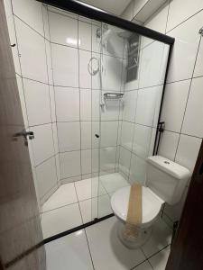 a bathroom with a toilet and a glass shower at Quarto com Ar Condicionado e banheiro no centro in Montes Claros