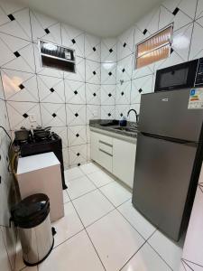 a kitchen with a black and white tiled wall at Apto com 2 quartos e A/C no Centro e Santa Casa in Montes Claros