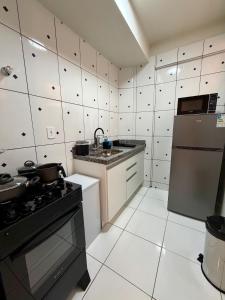 a kitchen with a stove and a refrigerator at Apto com 2 quartos e A/C ao lado da Santa Casa in Montes Claros